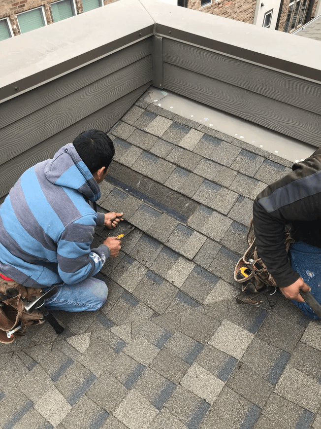 Roofers installing Class 4 impact-resistant shingles on a residential roof